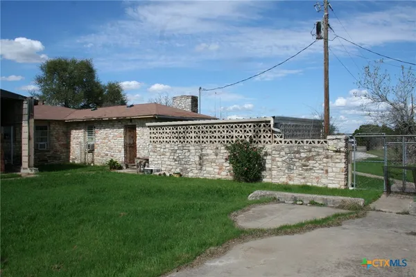 a backyard of a house with table and chairs