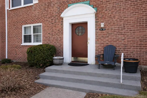 a front view of a house with barbeque and bench