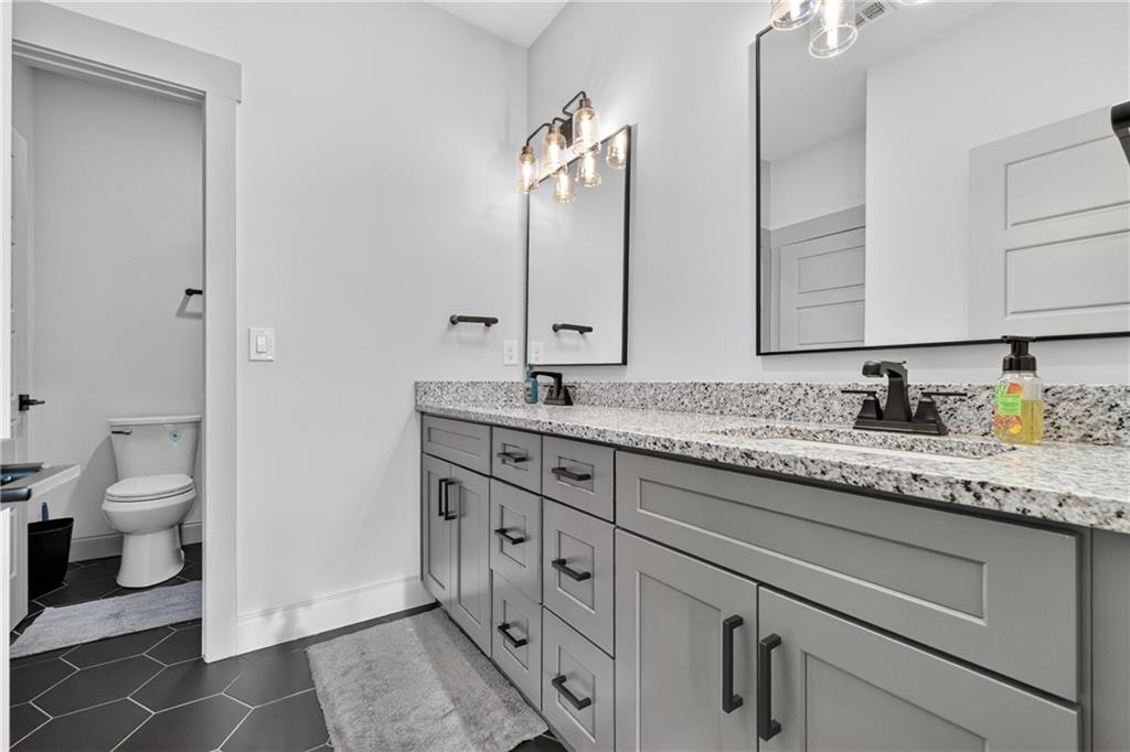 4726 Crestview Way Flowery Branch, GA 30542 - Photo 29 of 48 a bathroom with a granite countertop sink toilet and a mirror
