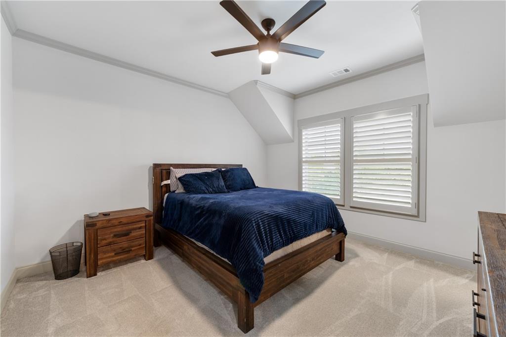 4726 Crestview Way Flowery Branch, GA 30542 - Photo 31 of 48 a spacious bedroom with a bed and a chandelier