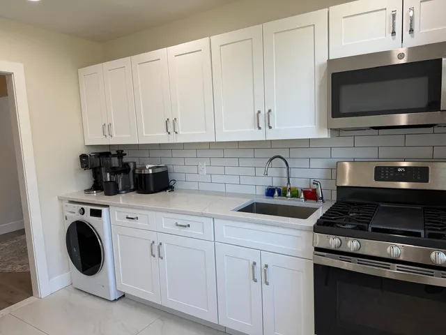 a kitchen with a stove and white cabinets