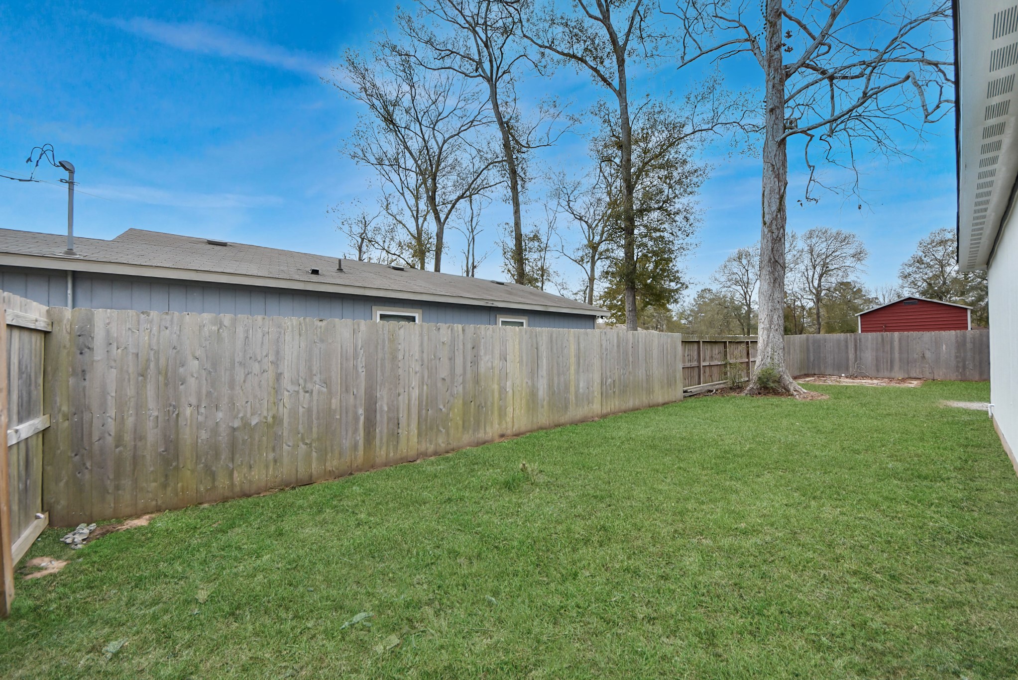 16124 Brettwood Lane Splendora, TX 77372 - Photo 30 of 40 a view of a backyard with wooden fence and a bench