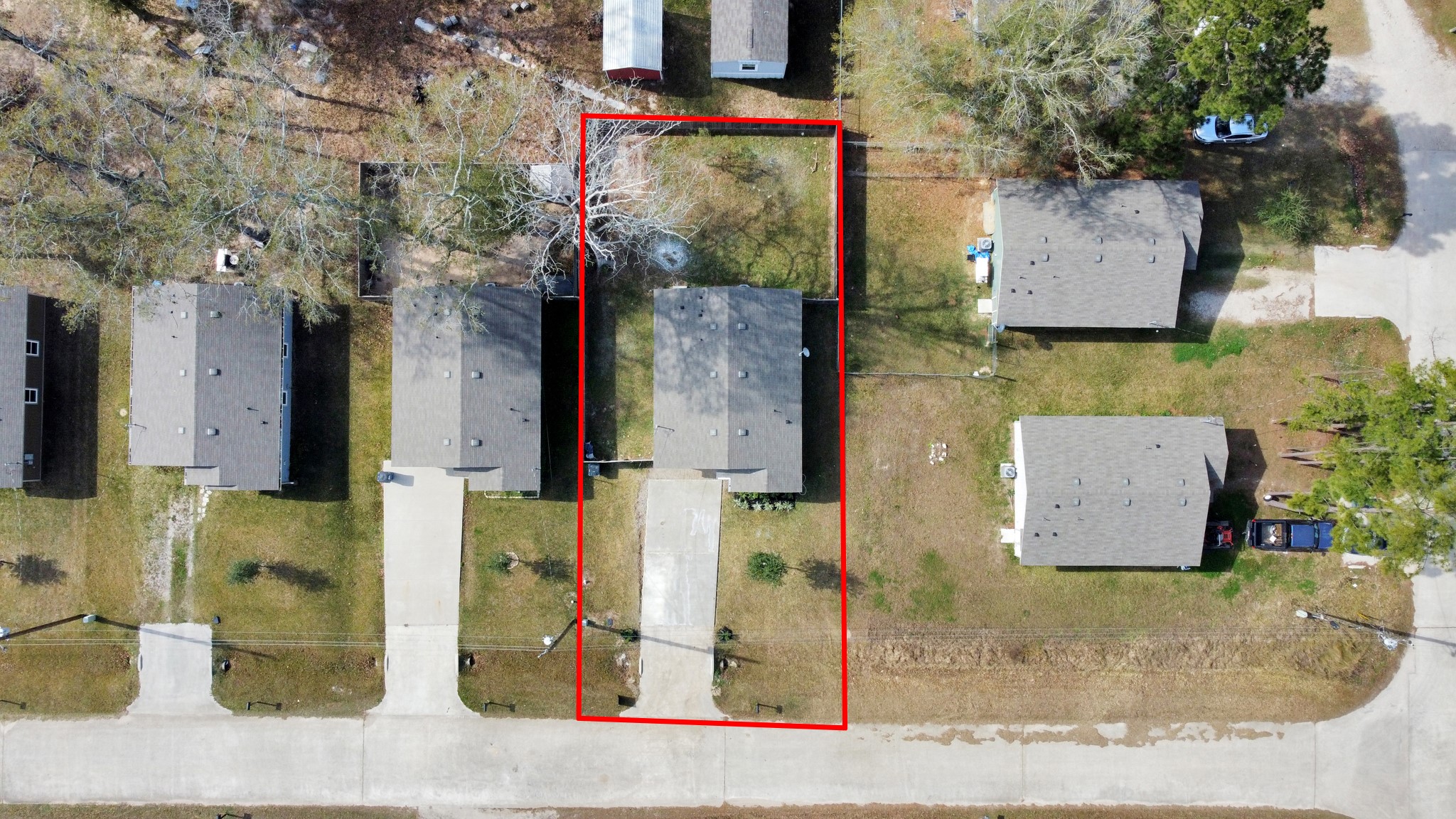 16124 Brettwood Lane Splendora, TX 77372 - Photo 37 of 40 This aerial photo shows a single-story home in a suburban neighborhood, highlighted by a red outline, with a driveway and a small backyard. The property is surrounded by similar homes on a quiet street, showcasing a tidy and organized community layout.