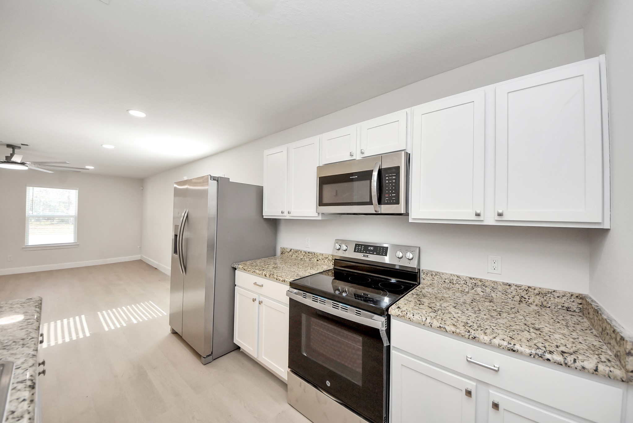 16124 Brettwood Lane Splendora, TX 77372 - Photo 9 of 40 a kitchen with stainless steel appliances granite countertop white cabinets and a stove