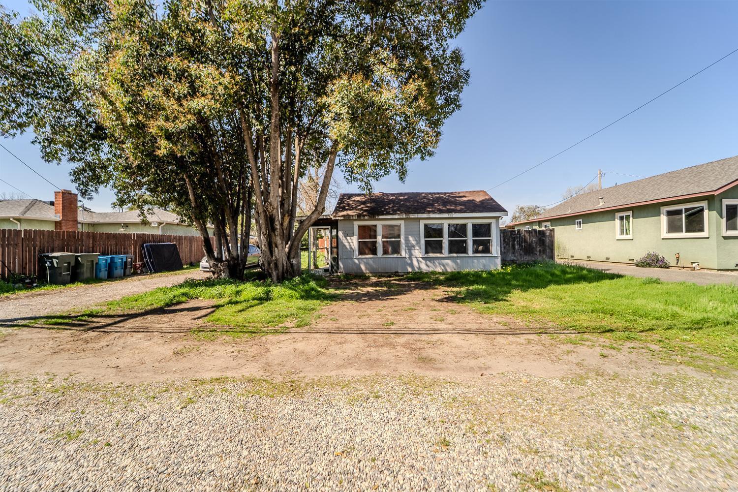 a front view of a house with a yard and trees