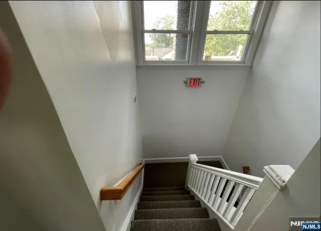 a view of a hallway with wooden floor and a window