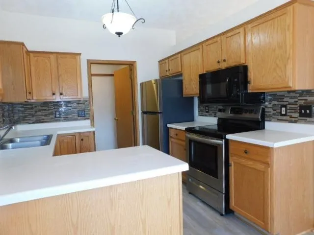 a kitchen that has a sink and a stove top oven