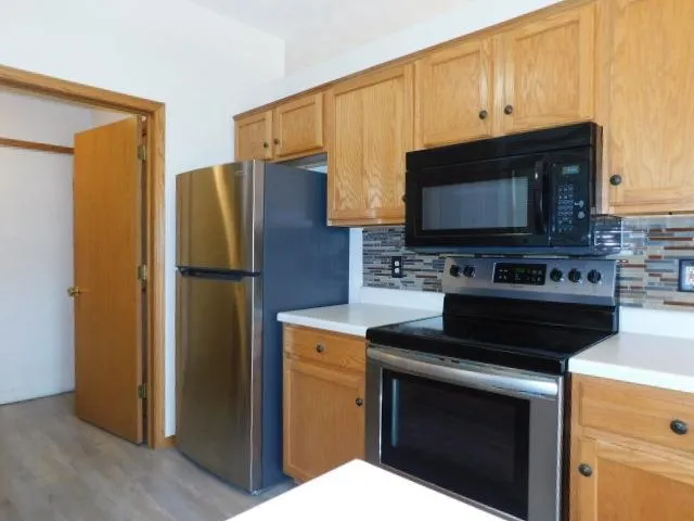 a kitchen with stainless steel appliances a stove microwave and refrigerator
