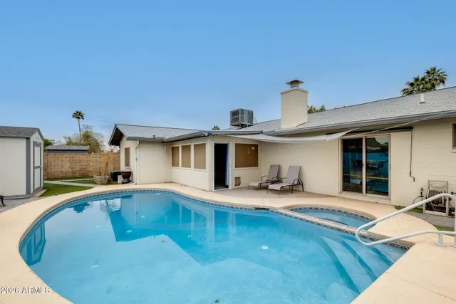 a swimming pool with outdoor seating and yard