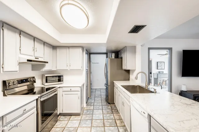 a kitchen with a sink a stove top oven and refrigerator