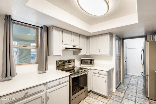 a kitchen with granite countertop a stove cabinets and counter space