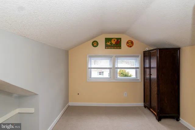 a view of backyard with wooden fence and large trees