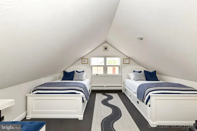 a view of a house with a small yard and large trees