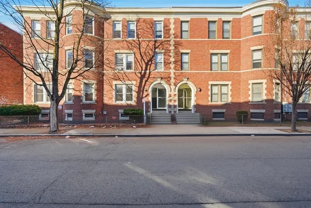 a front view of a residential apartment building with a yard