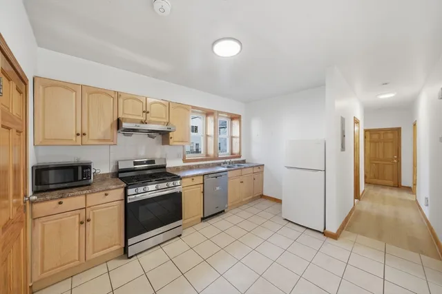 a kitchen with stainless steel appliances granite countertop a stove a sink and a refrigerator