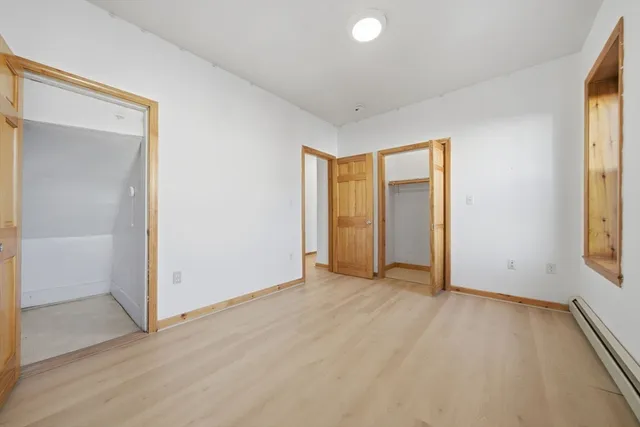 an empty room with windows and closet