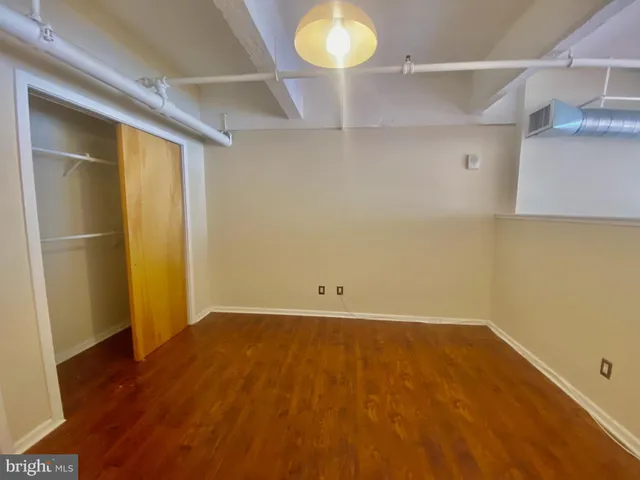 an empty room with wooden floor and cabinet