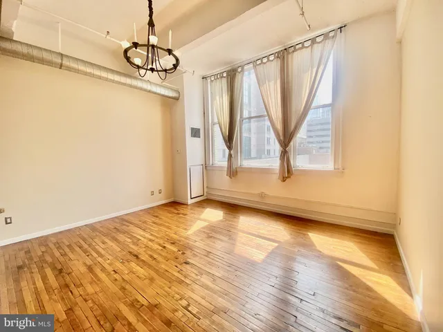a view of a room with wooden floor and windows