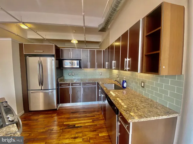 a kitchen with stainless steel appliances granite countertop a refrigerator and a sink