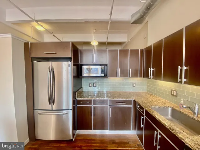 a kitchen with kitchen island granite countertop a sink appliances and cabinets