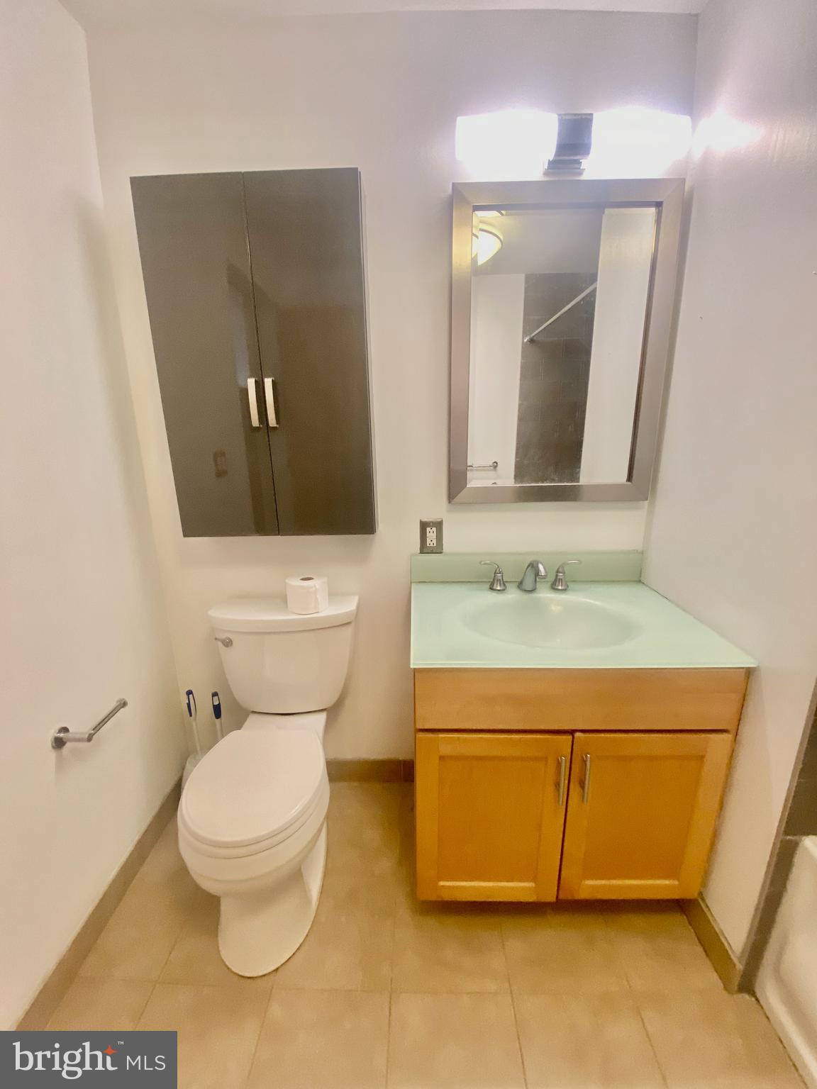 1228-32 Arch Street, Unit 5C Philadelphia, PA 19107 - Photo 9 of 34 a bathroom with a toilet a sink and mirror