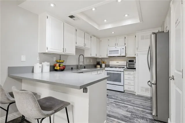 a kitchen with cabinets stainless steel appliances and a window