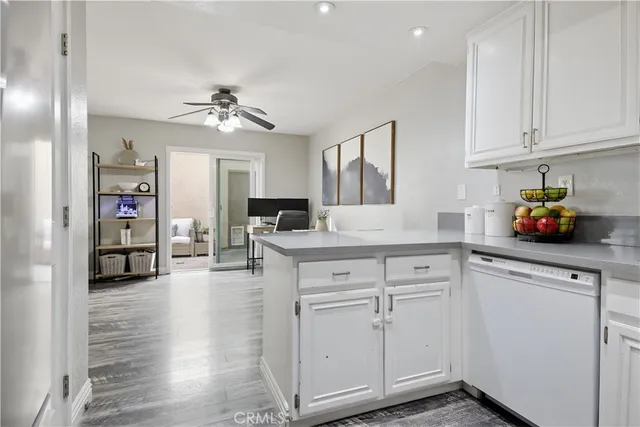 a kitchen with white cabinets and chandelier