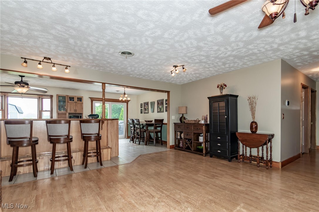 5081 Middle Ridge Road Perry, OH 44081 - Photo 3 of 33 Kitchen featuring ceiling fan, rail lighting, light wood finished floors, and a kitchen bar.
View of dining area and back sliding door.