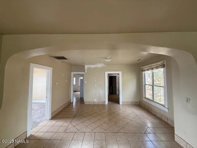 a view of empty room with a window and a ceiling fan