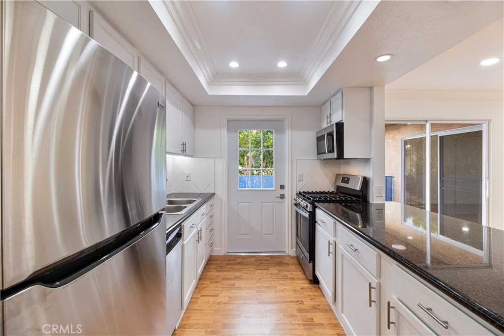 a kitchen with granite countertop a stove sink and refrigerator