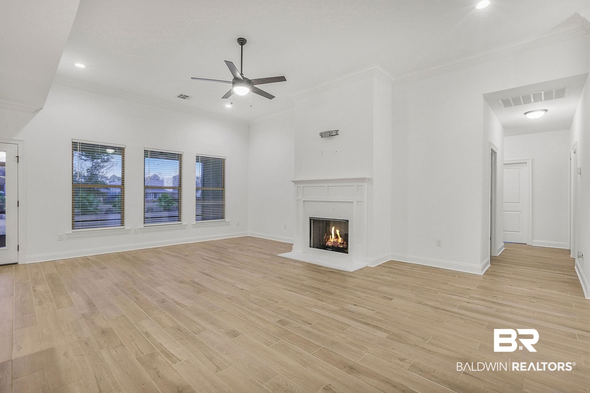 9855 Chipper Lane Foley, AL 36535 - Photo 7 of 48 Unfurnished living room featuring ceiling fan, light hardwood / wood-style floors, and crown molding