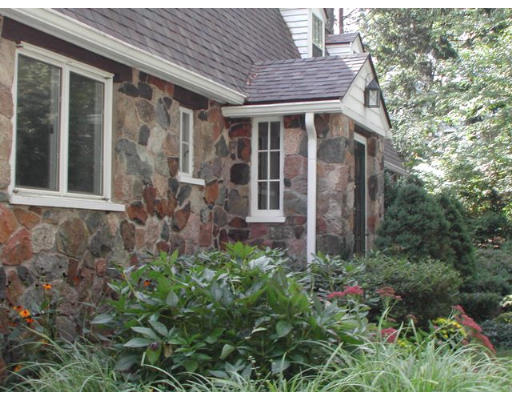 18 Woodridge Road Wellesley, MA 02482 - Photo 15 of 20 a view of a brick house with a large windows and flower plants