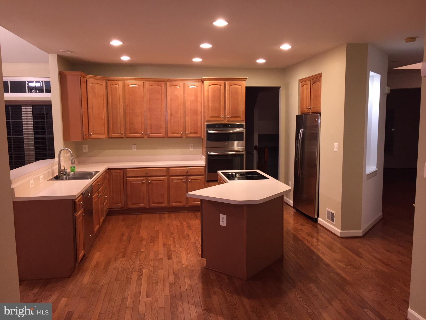 215 Maddex Square Drive Shepherdstown, WV 25443 - Photo 2 of 16 a kitchen with kitchen island a sink wooden floor and stainless steel appliances