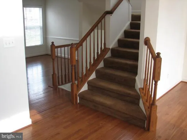 a view of staircase with wooden floor and a window