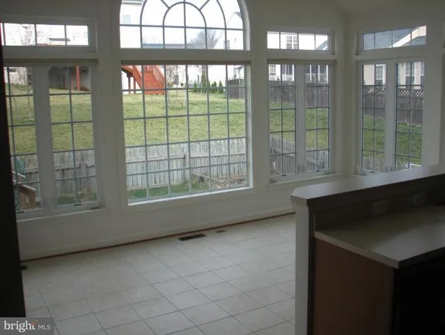a view of an empty room with a floor to ceiling window and brick walls