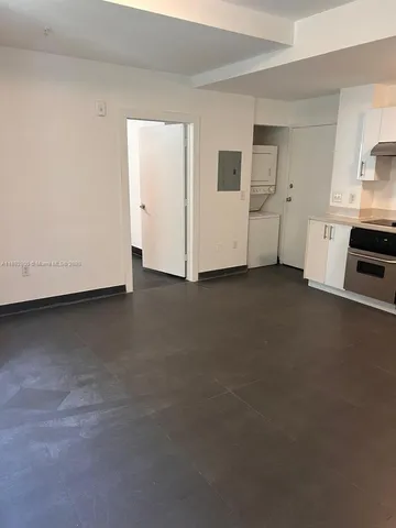 a view of a kitchen with refrigerator and white cabinets
