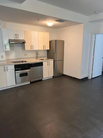 a kitchen with refrigerator and cabinets