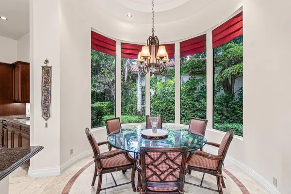 a living room with furniture a rug staircase and a large window