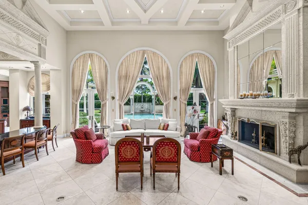 a living room with furniture a fireplace and large windows