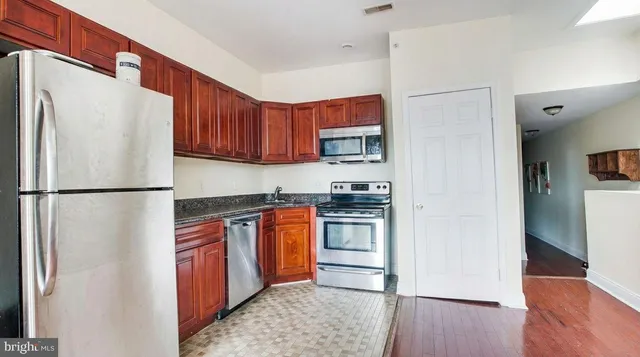 a kitchen with stainless steel appliances granite countertop a refrigerator sink and cabinets