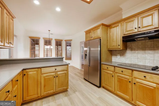 a view of a kitchen with a refrigerator a microwave and a sink