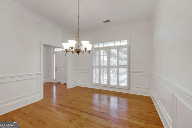 a view of a room with wooden floor and chandelier