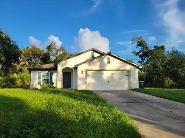 a view of a house with a yard and a garden
