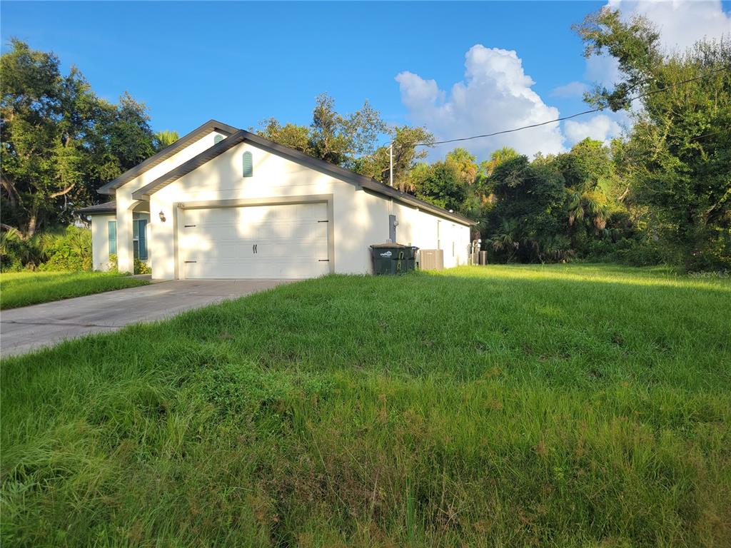 2350 Firebrand Road North Port, FL 34288 - Photo 4 of 6 a front view of a house with a yard and garage