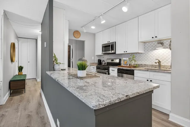 a kitchen with granite countertop kitchen island sink stove and refrigerator