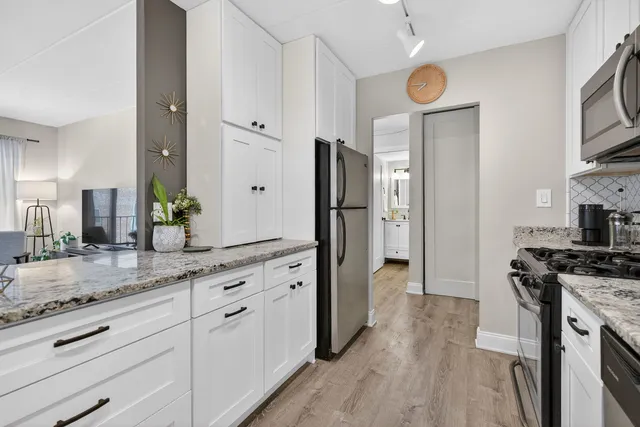 a kitchen with white cabinets and stainless steel appliances