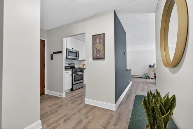 a view of a hallway with wooden floor and a dining room