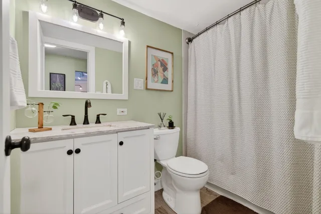 a bathroom with a toilet a sink and mirror