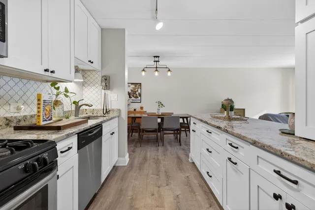 a kitchen with granite countertop a sink stove and cabinets