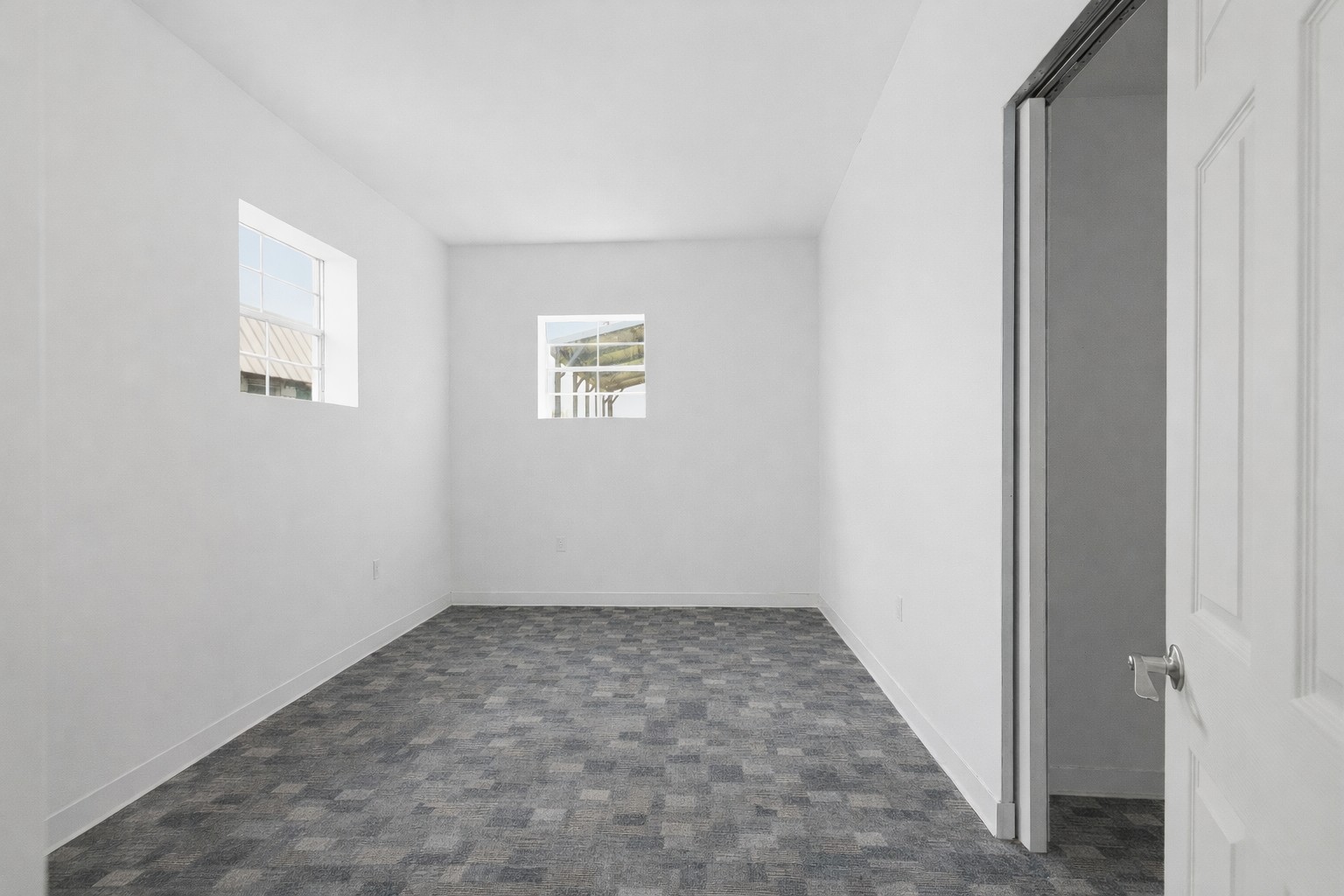 224 Old Coach Lane Elgin, TX 78621 - Photo 12 of 25 This interior room features white walls, two windows, and patterned grey flooring